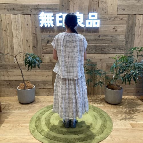 チェックのセットアップを着て後ろを向いて立つ女性