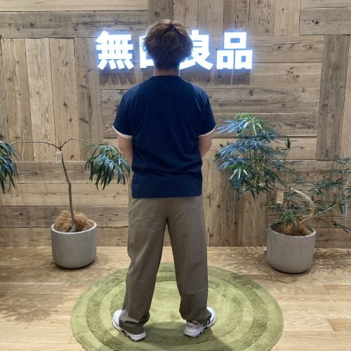 ネイビーのTシャツを着て後ろを向いて立つ男性