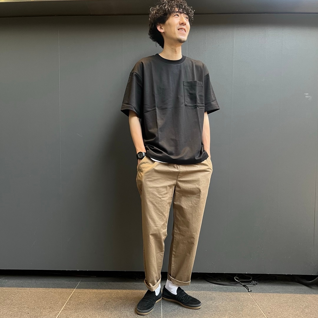 黒のTシャツ、ベージュのパンツでコーディネート