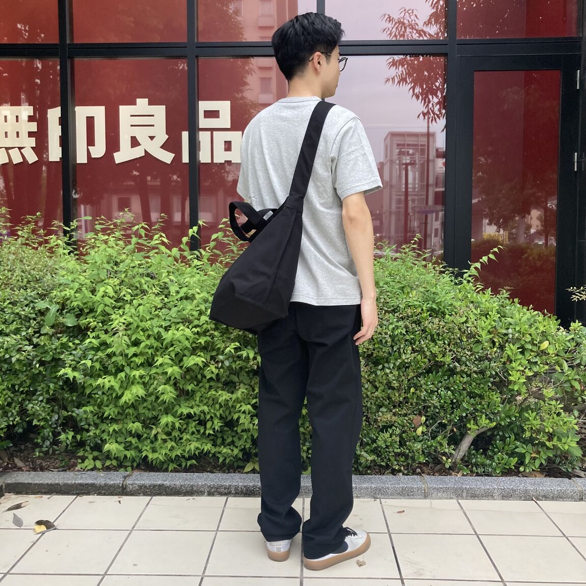 トートバッグを背負った半袖の男性