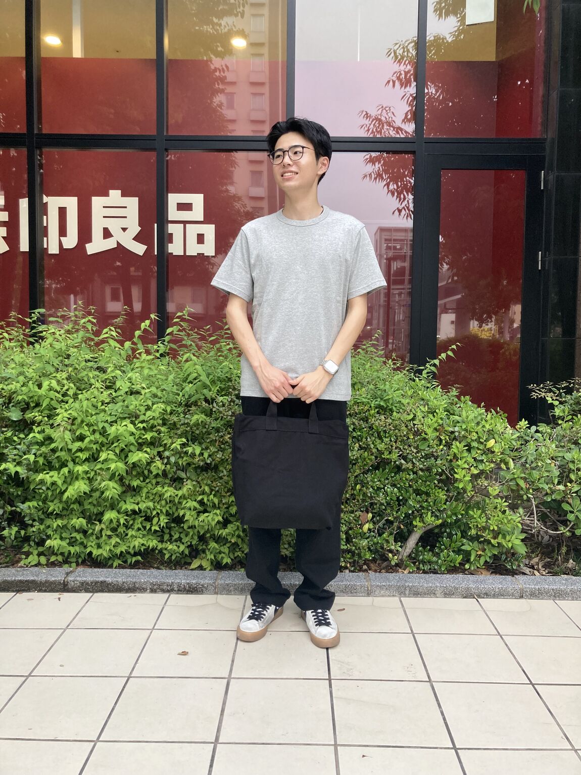 トートバッグを背負った半袖の男性