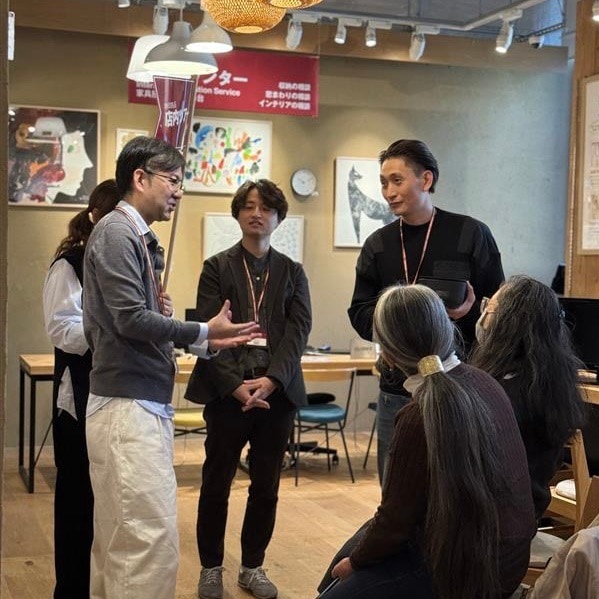 スタッフの案内のもと、少人数で売場の特徴や商品を学ぶ無印良品の店舗ツアーの場面