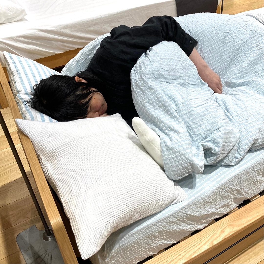 サッカー織寝具で寝ている女性