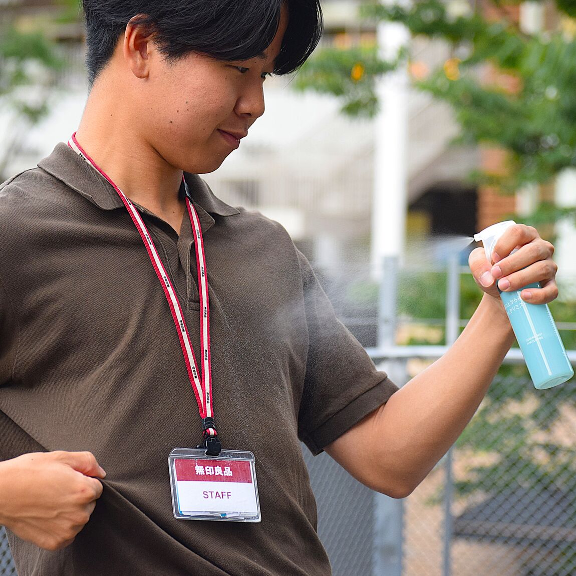 服にかけるクールスプレーを服にかけてる人