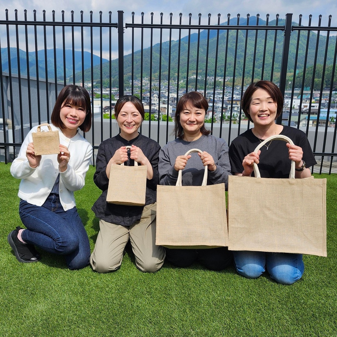 四人でバックを持って青空