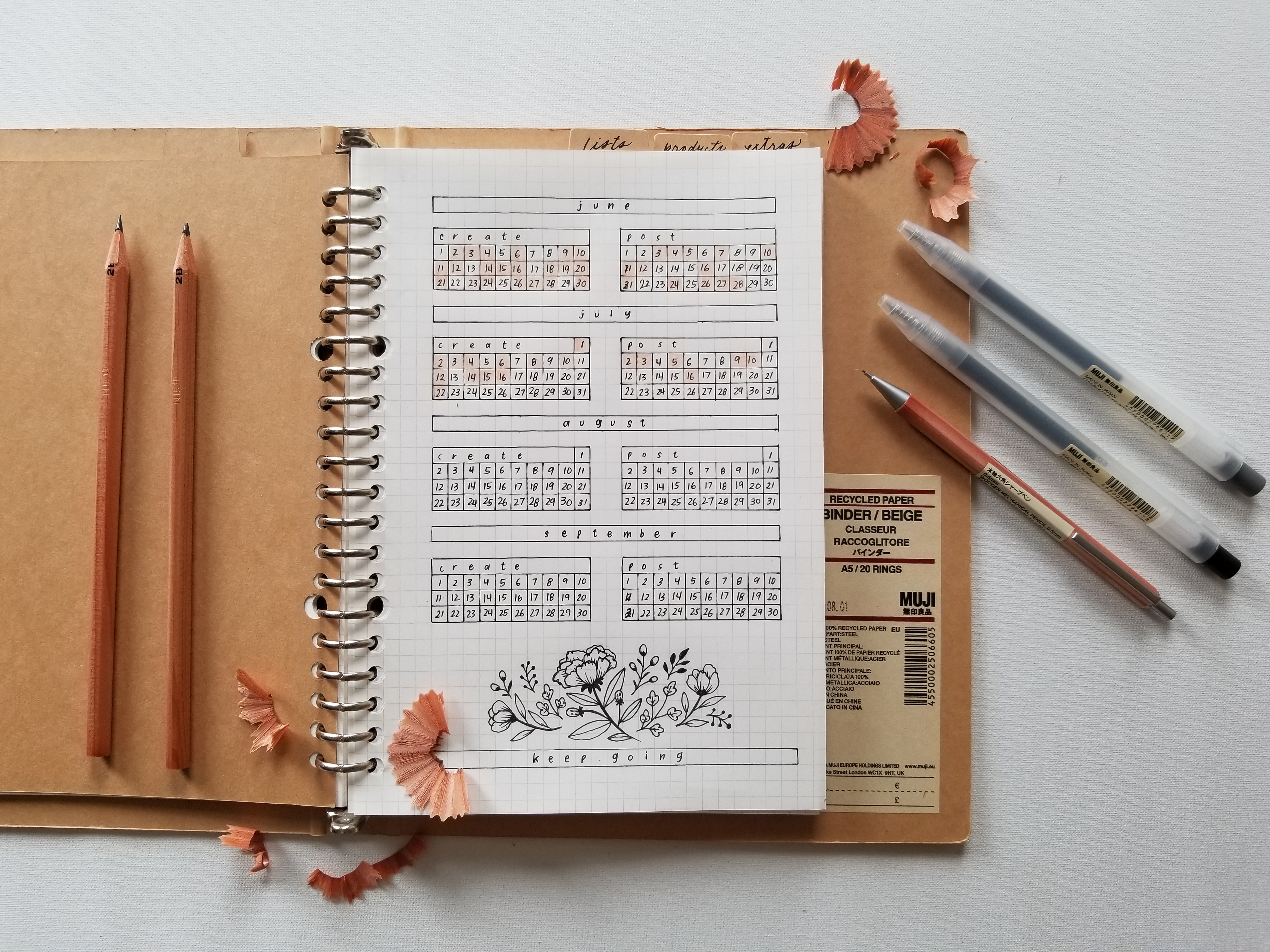 Bullet Journal An image of a single-page bullet journal spread inside a MUJI binder and graph paper. MUJI stationary surrounds the binder as decoration.